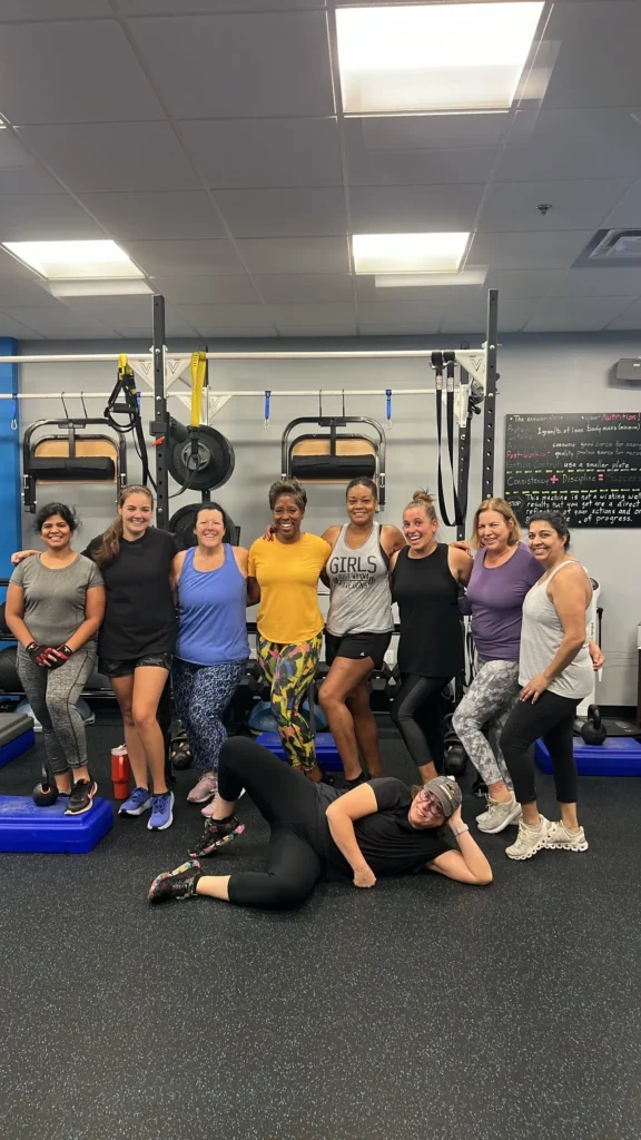 Group of diverse women posing together in a fitness studio.