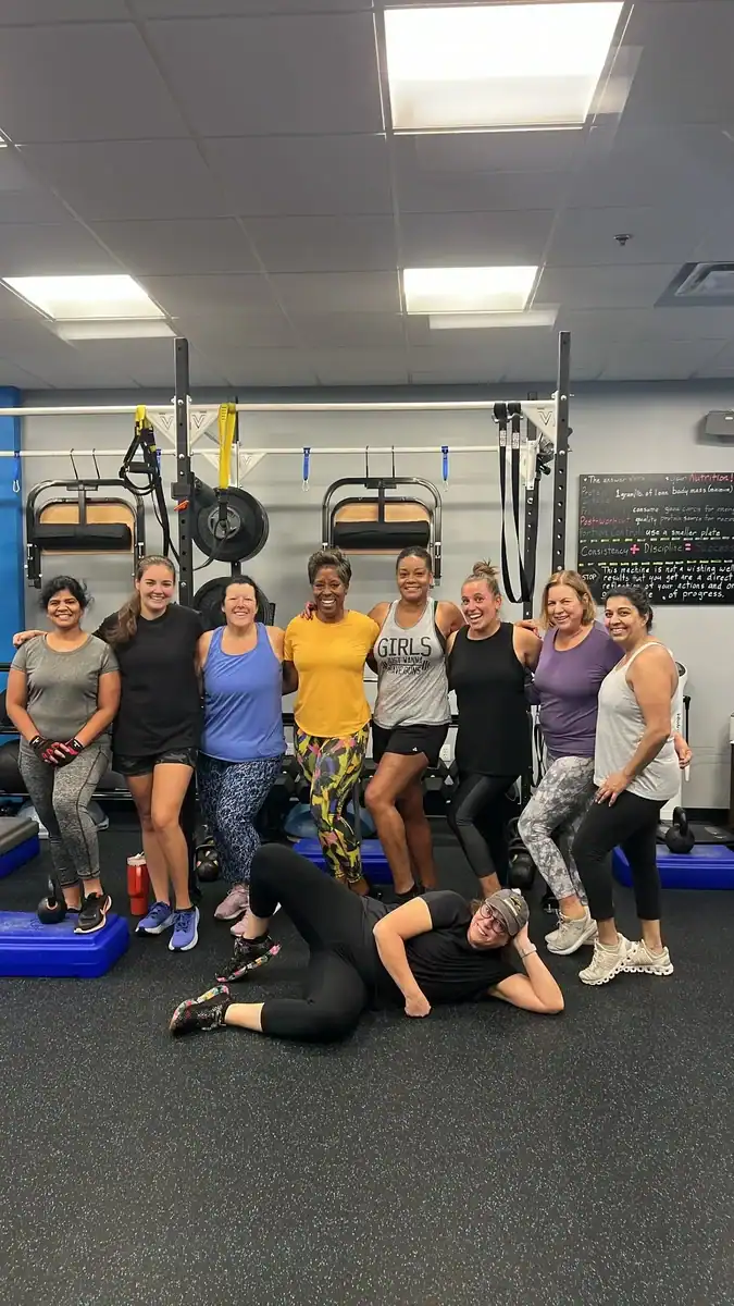 Group of diverse women posing together in a fitness studio